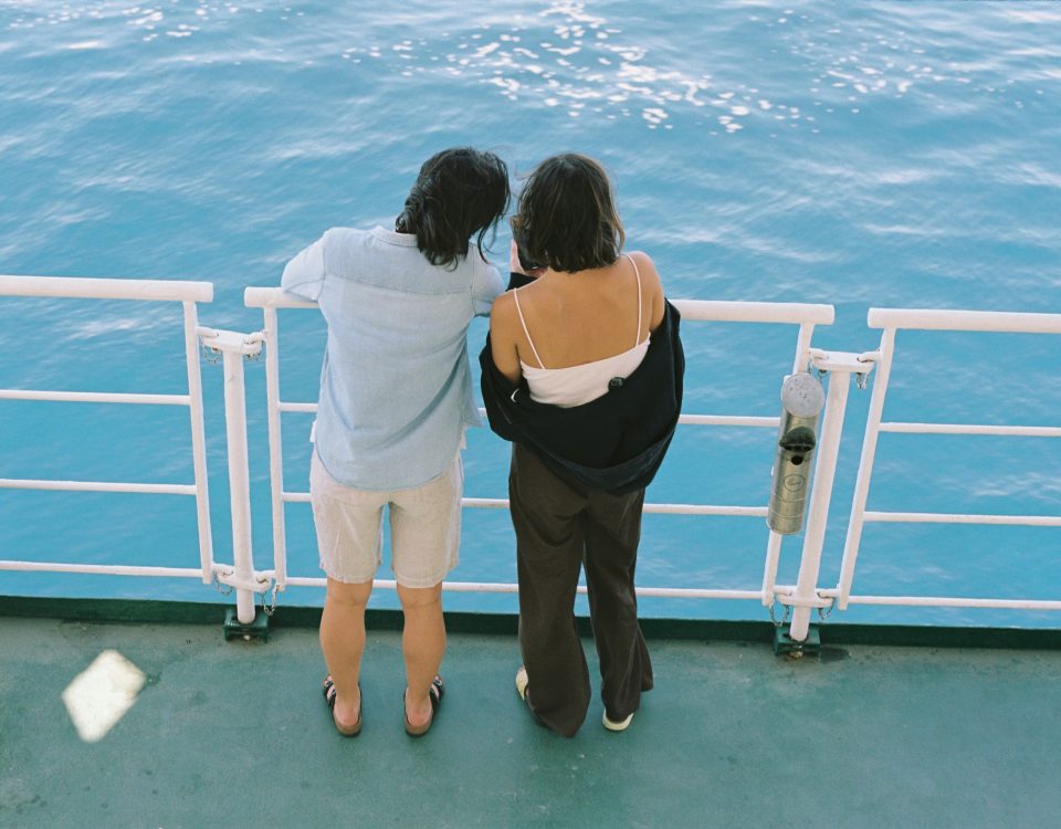 A couple looks into the water over a railing.