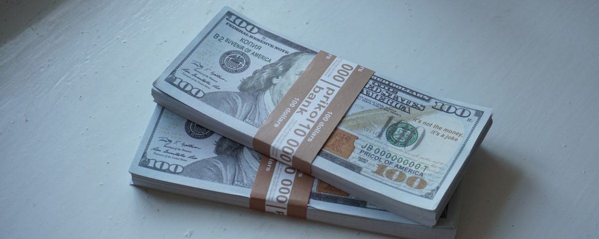 Hundred dollar bills in stacks.