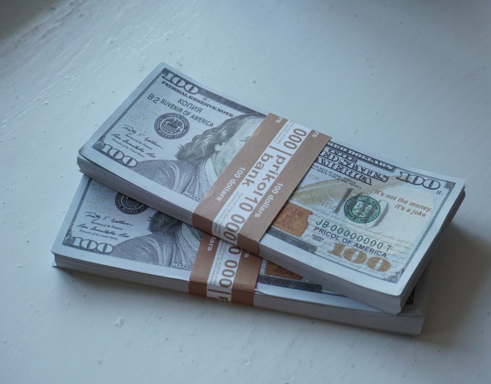 Hundred dollar bills in stacks.