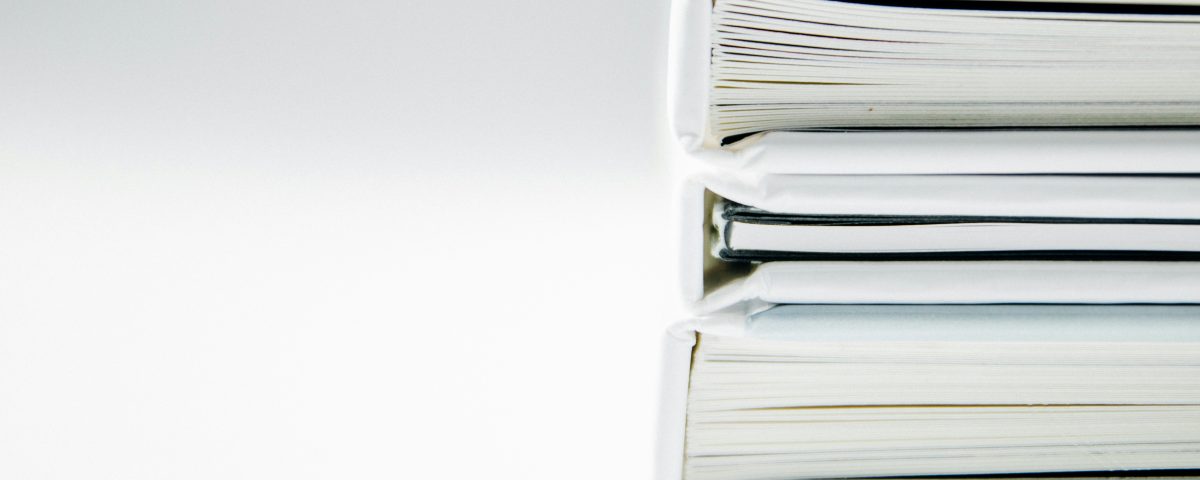 White binders stacked on top of each other.