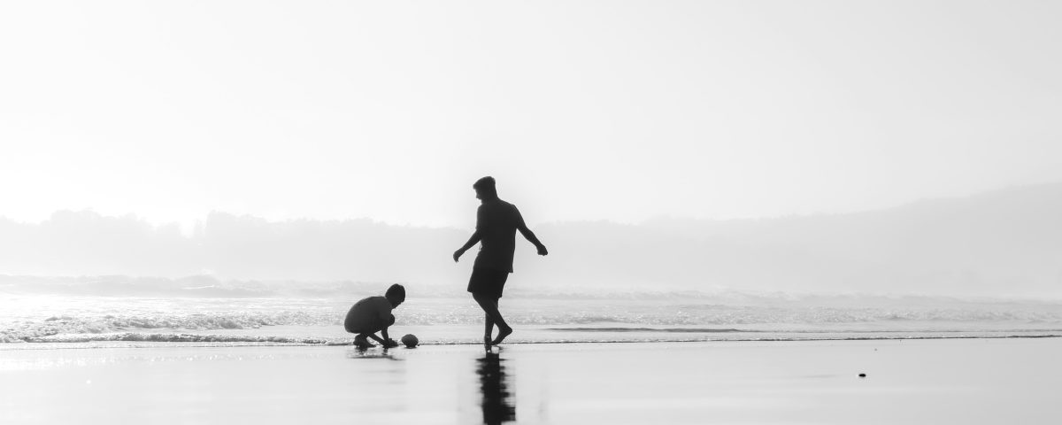 Two people play on the beach.