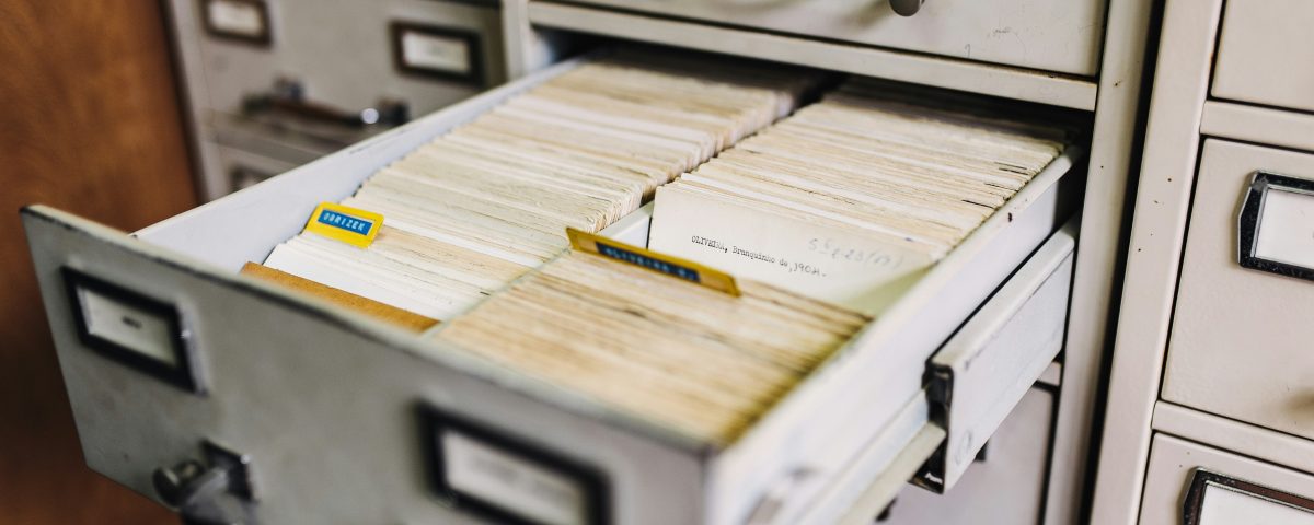 A filing cabinet drawer open with files in it.