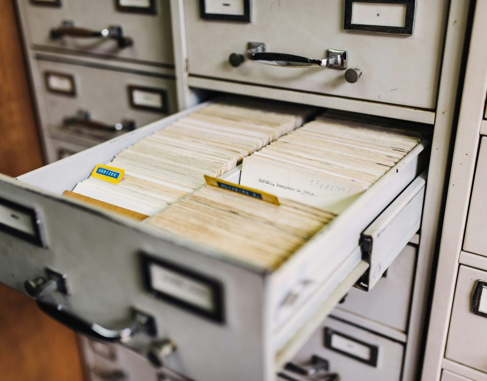 A filing cabinet drawer open with files in it.