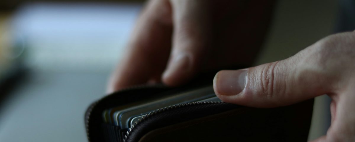 Hands opening a wallet.