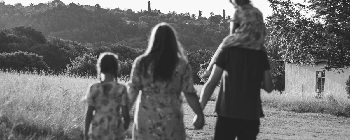 A black and white image of a family walking away.